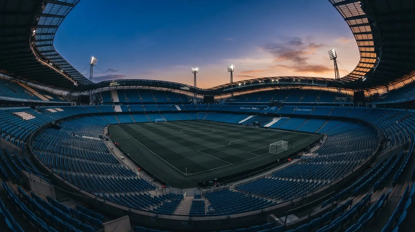 Een leeg voetbalstadion met lichtmasten bij schemering