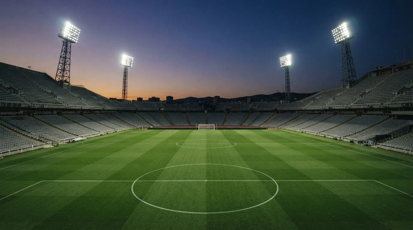 Een leeg voetbalstadion met lichtmasten bij schemering
